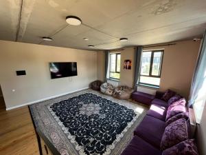 a living room with a couch and a rug at Hostel 78 in Karakol