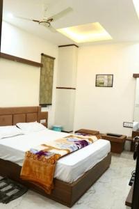 a bedroom with two beds and a ceiling at Crown Palace Hotel & Restaurant in Hāpur +10 photos