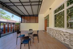 a room with a table and chairs on a deck at Nan's 2 Bedroom House in Krabi