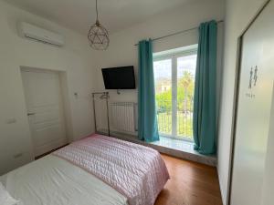 a bedroom with a bed and a window with blue curtains at Terrazza Vanvitelli in Caserta
