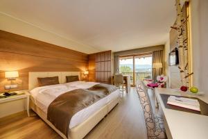 a hotel room with a large bed and a desk at Art & Design Hotel Napura in Bolzano +62 photos