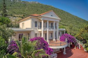 a house with purple flowers in front of a hill at TEKCE Villa Motto N21 in Kaş