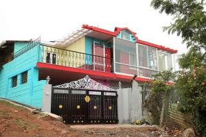 a colorful house with a gate in front of it at Sunshine retreat in Coonoor