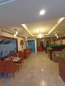 a dining room with tables and chairs in a restaurant at Crown Palace Hotel & Restaurant in Hāpur