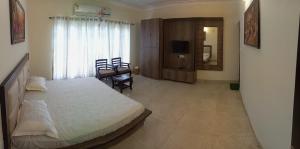 a bedroom with a large bed and a television in it at Adarsh villa in Dharmsāla