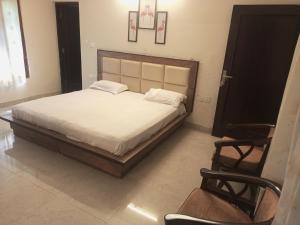a bedroom with a large bed and a chair at Adarsh villa in Dharmsāla +11 photos
