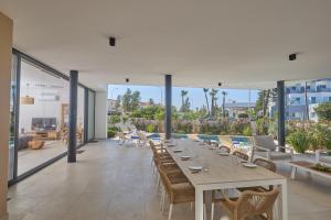 a dining room with a long table and chairs at Aqua Pearl Villas in Protaras