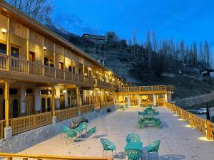 a building with a patio with chairs and tables at Hunza Embassy Hotel by Zeez in Karimabad Hunza
