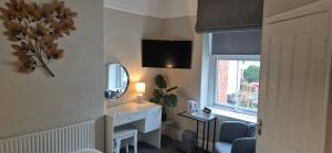 a room with a desk and a mirror and a window at Glencoe Guest House in Keswick