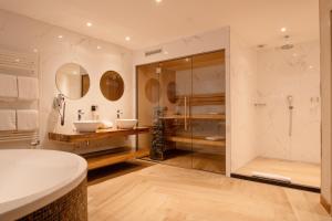 a bathroom with two sinks and a shower at Van der Valk Hotel Hollands Kroon in Wieringerwerf