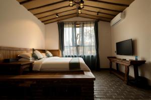 a bedroom with a large bed and a television at 唐韵驿馆 in Dunhuang