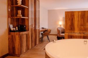 a bathroom with a bath tub and a desk at Van der Valk Hotel Hollands Kroon in Wieringerwerf