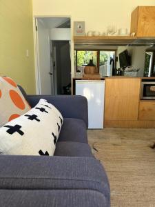 a living room with a blue couch and a kitchen at Little Banks in Robe