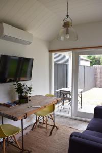 a living room with a wooden table and a tv at Little Banks in Robe