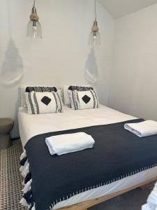 a bedroom with a bed with black and white pillows at Little Banks in Robe