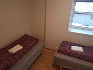 a small room with two beds and a window at Evjen H0101 in Tromsø