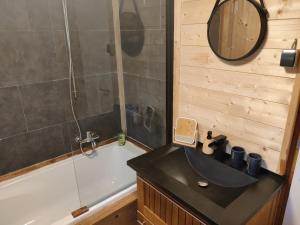 a bathroom with a sink and a tub and a mirror at Chalet La Roche 231 in Rendeux +5 photos