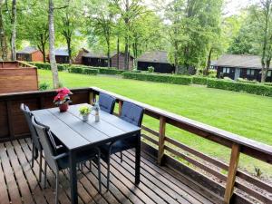 a table and chairs on a deck with a yard at Chalet La Roche 231 in Rendeux