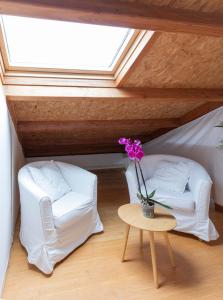 a room with two chairs and a table with a vase of flowers at NAMOR - Buhardilla Zen in Ribadeo