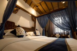 a bedroom with a bed with blue curtains and a window at 唐韵驿馆 in Dunhuang