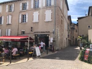 a group of people sitting at tables in front of a building at La Chantrerie in Cahors