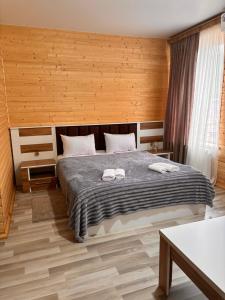 a bedroom with a bed with two towels on it at Hotel okriba in Tqibuli