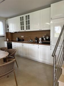 a kitchen with white cabinets and a table and chairs at Villa Olivia Skioni in Nea Skioni