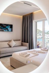 a bedroom with a bed and a couch and a mirror at Mariana Apartments in Sarandë