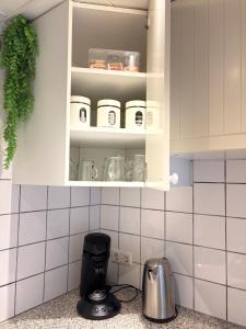 a kitchen counter with a cupboard with jars on it at Studio Watertoren in Goes +20 photos