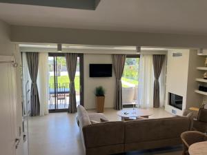 a living room with a couch and a table at Villa Olivia Skioni in Nea Skioni