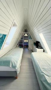 two beds in a white room with a window at Villa Aurora in Waldbrunn