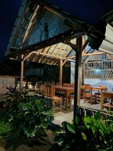 a wooden pavilion with wooden tables and chairs at Tetebatu Backpackers Base in Selong
