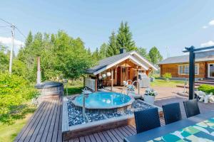 a backyard with a hot tub and a cabin at Villa Veneskoski in Veneskoski +8 photos