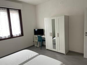 a bedroom with a white cabinet and a desk with a computer at B&B Il Viale in Ponte dellʼOlio
