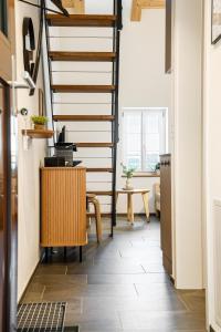 a staircase in a room with a table and a chair at Appartements Lago in Tüscherz-Alfermée