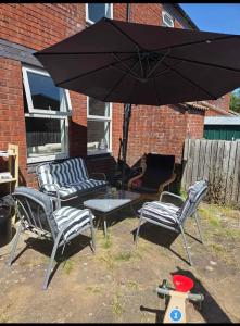 a group of chairs and a table and an umbrella at Clover Ground Home in Bristol