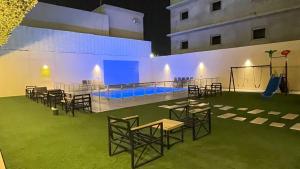a room with chairs and tables and a pool at دولف للشقق الفندقية حي المصيف in Hail
