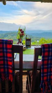 a table with a vase of flowers on top of it at Bwindi Neckview Lodge in Buhoma