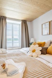 a bedroom with a large bed with a stuffed animal on it at Appartements Lago in Tüscherz-Alfermée