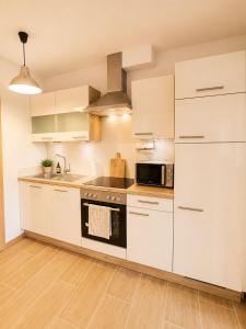 a kitchen with white cabinets and a stove top oven at Apartment Harbach in Harbach