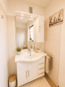 a white bathroom with a sink and a mirror at Apartment Harbach in Harbach