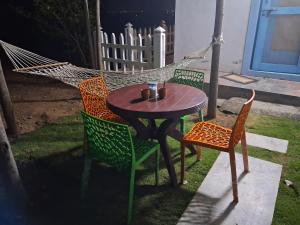 a patio table and chairs with a hammock at ViRa Farm in Sūlagiri