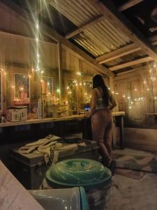 a woman standing in a kitchen preparing food at Mansa Homestay in Kalgha +60 photos