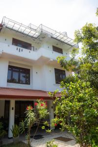 a white building with trees in front of it at Diana Residence in Matara