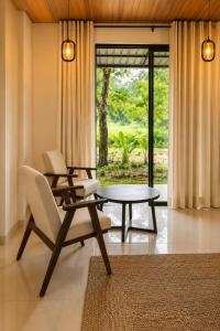 a living room with a table and a chair at Myla Lodge in Anuradhapura