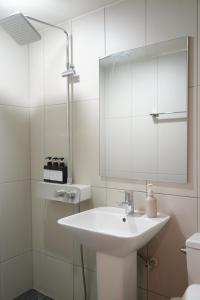 a white bathroom with a sink and a mirror at Hotel Azure Incheon in Incheon +32 photos