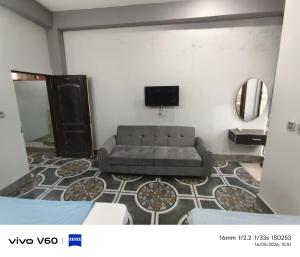 a living room with a couch and a tv at Al Qadir Residence in Multan
