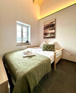 a small bedroom with a bed and a window at Appartements Lago in Tüscherz-Alfermée