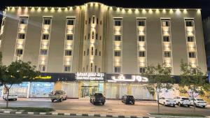 a large white building with cars parked in front of it at دولف للشقق الفندقية حي المصيف in Hail
