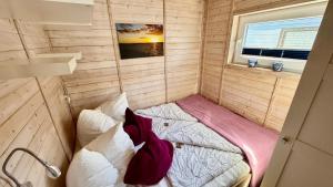 a small room with two beds in it with a window at Hausboot Lilla Lina in Fehmarn +20 photos